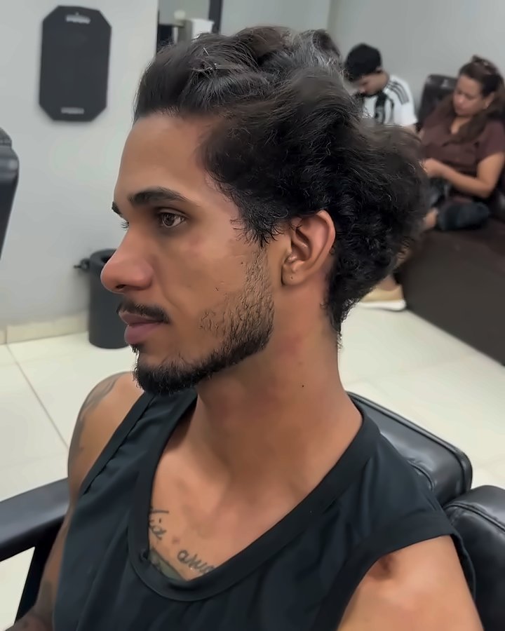 Cliente de perfil com o cabelo ondulado, comprido e armado, antes