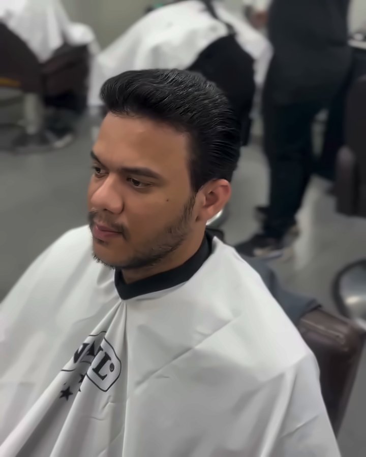 O mesmo cliente com o cabelo liso e penteado para trás, depois