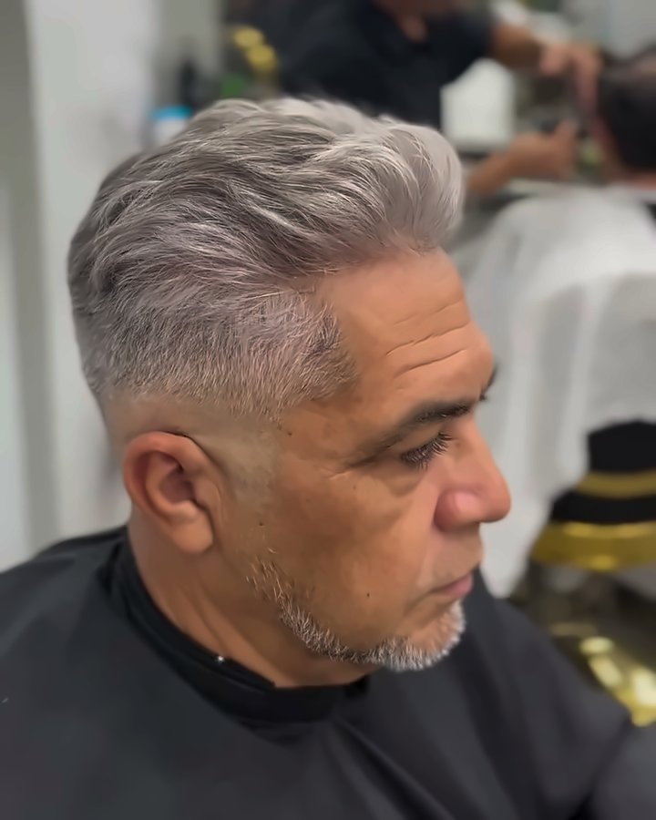 O mesmo cliente com o cabelo grisalho alinhado e penteado, depois